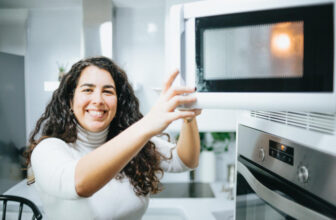Mulher abrindo porta do microondas